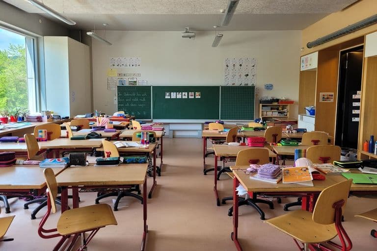 A classroom filled with lots of desks and chairs